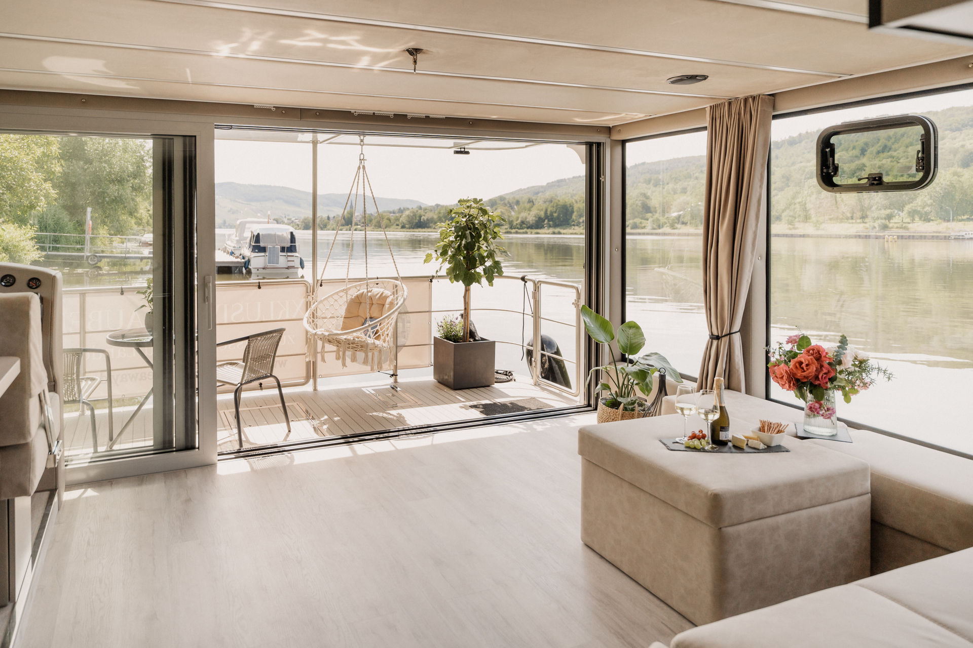 Heller, modern eingerichteter Wohnraum im Hausboot Solejo mit Panoramafenstern zur Mosel