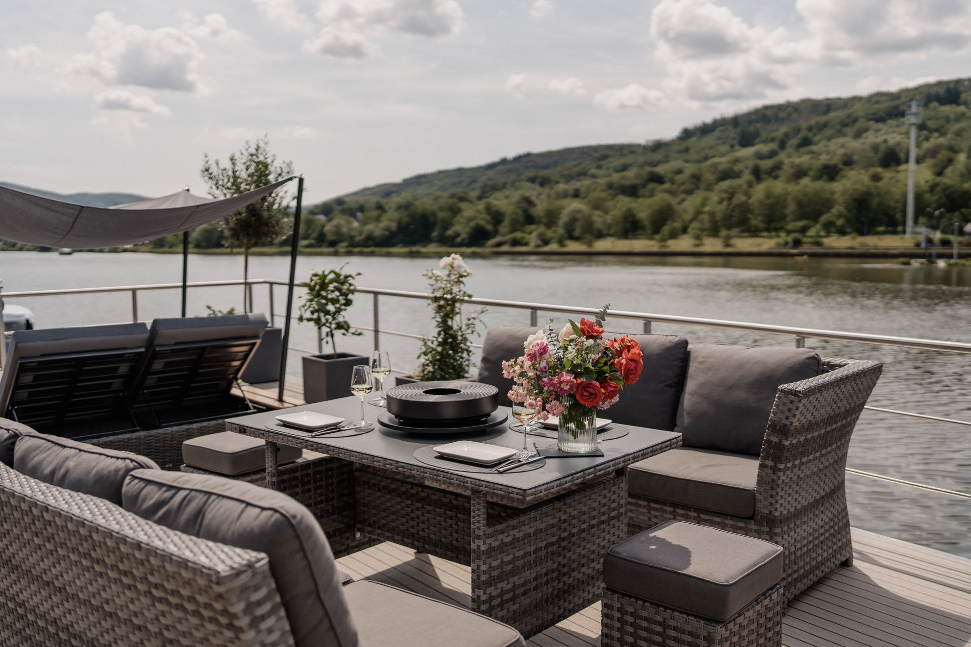 Sonnenterrasse des Hausboots Solejo mit Loungemöbeln und Blick auf die Mosel und die Weinberge